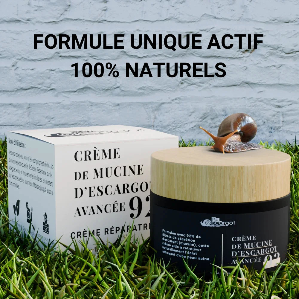 Pot de crème de mucine d'escargot avancée avec un couvercle en bois et une boîte d'emballage sur un fond d'herbe, accompagné d'un escargot, mettant en avant sa formule réparatrice 100% naturelle.